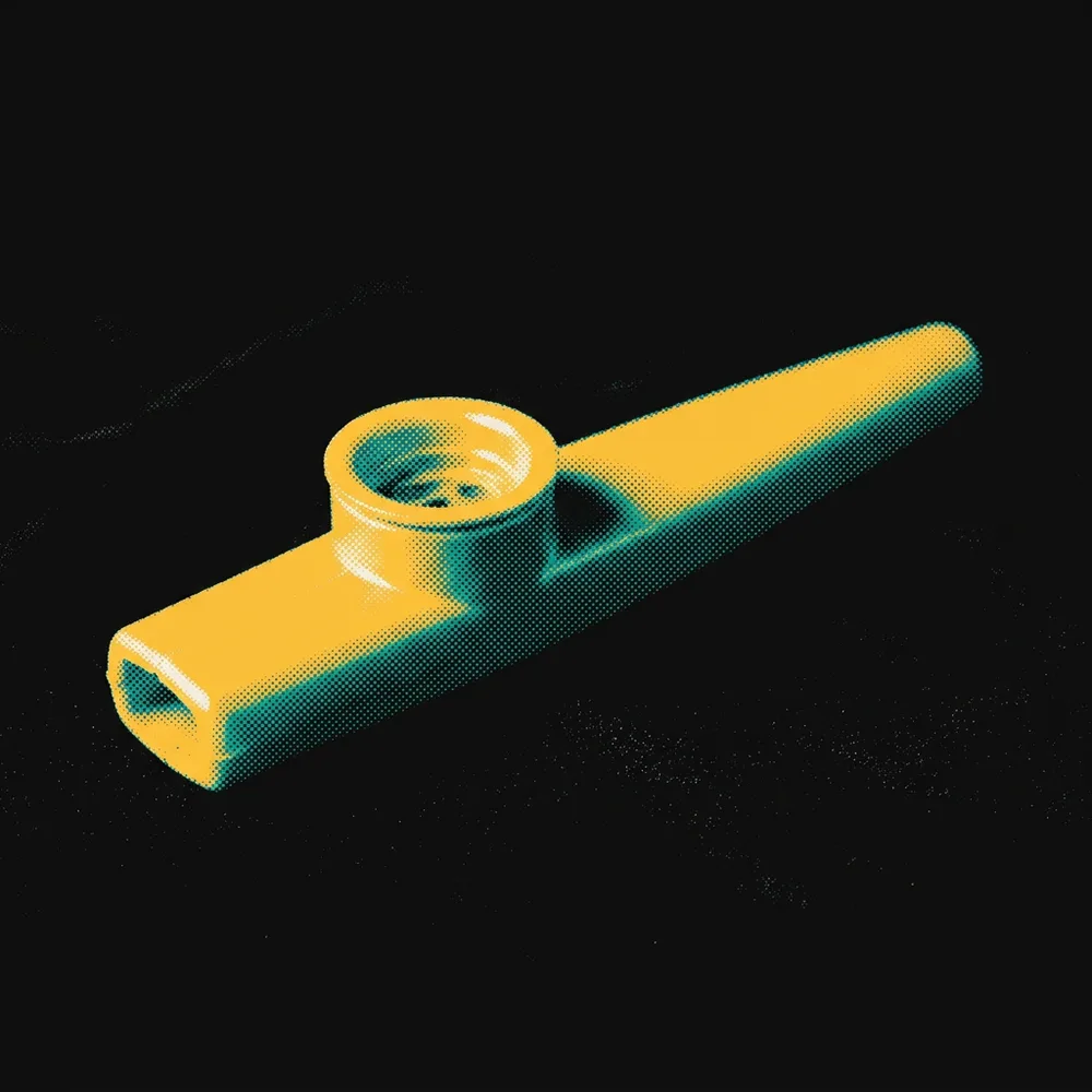 A single kazoo lit like a museum piece against a black background.